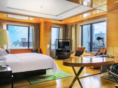 - une chambre avec un lit, un bureau et une télévision dans l'établissement Renaissance Bangkok Ratchaprasong Hotel, à Bangkok