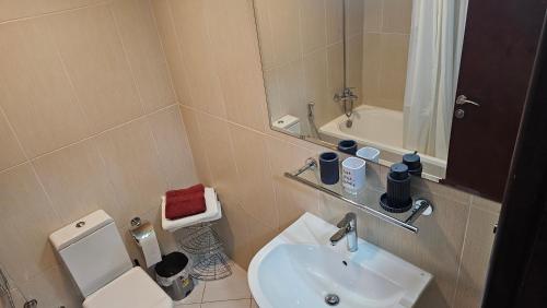 uma casa de banho com um lavatório, um WC e um espelho. em Sea view near the beach 2 em Ras al-Khaimah