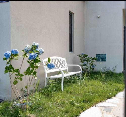Jois House في جيجو: مقعد أبيض موضوع على العشب بجوار مبنى