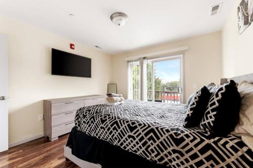 een slaapkamer met een zwart-wit bed en een televisie bij Hidden Gem in Philadelphia