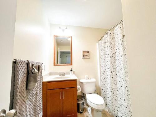 uma casa de banho com um WC, um lavatório e um espelho. em Hidden Gem em Filadélfia