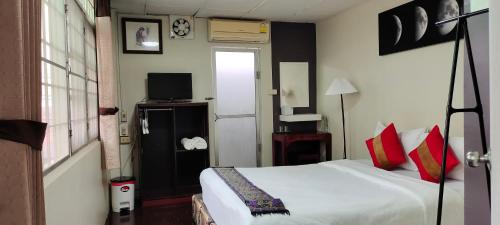 - une chambre avec un lit et une télévision dans l'établissement Born Guest House, à Chiang Mai
