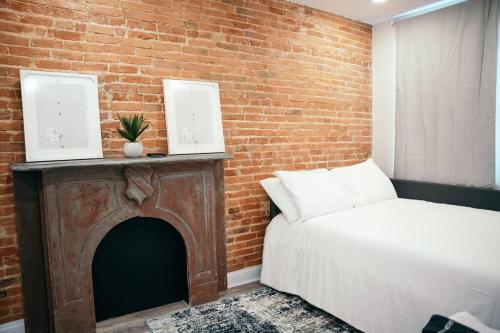 a bedroom with a bed and a brick wall at Sleek and Cozy Micro Fells Point Residence! in Baltimore