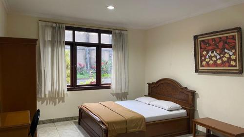 una camera con letto e finestra di Green Hill Resort Kemuning a Panyaweuyan