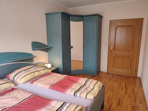 a bedroom with a bed and a blue cabinet at Ferienhaus Schöller in Schönbach