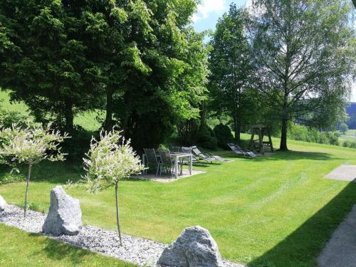 a park with a picnic table and rocks in the grass at Ferienhaus Schöller in Schönbach