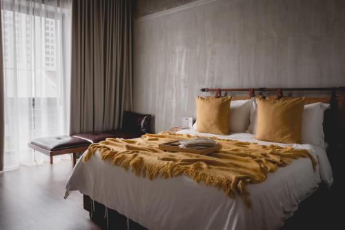 a bedroom with a large bed with a blanket on it at Hotel Mokozoyo in George Town