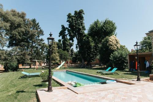 a pool with a person laying in the grass at La Parenthèse Fléchoise, Gîte in La Flèche