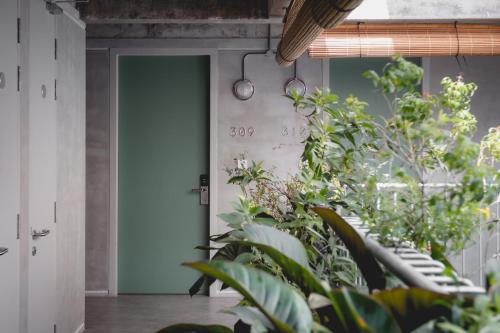 a hallway with plants in front of a door at Hotel Mokozoyo in George Town
