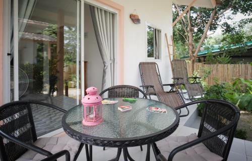 a glass table with a pink lantern on a patio at Enda Lanta Bungalows in Ko Lanta