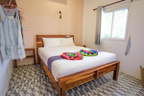 1 dormitorio con 1 cama con sábanas blancas y ventana en Enda Lanta Bungalows en Ko Lanta