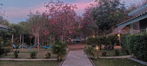 a garden with two hammocks in the yard at Enda Lanta Bungalows in Ko Lanta
