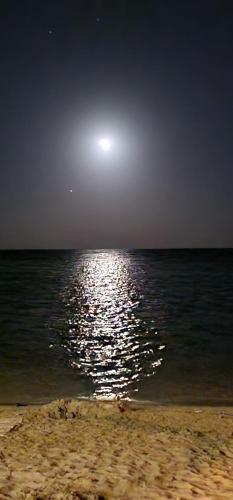 a moon reflecting on the water at the beach at La Casa sulla Spiaggia in Marzamemi