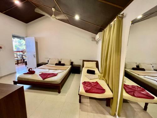 a room with two beds and a table at Fatima Guest House in Baga