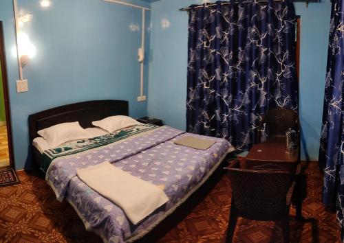 um quarto com uma cama com paredes azuis e uma mesa em Dream River Guest House em Pahalgam