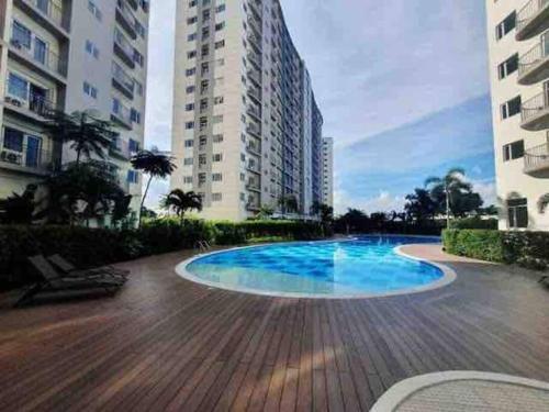 a swimming pool in front of some tall buildings at 1 BR South Residences SM Southmall Netflix / Alexa in Manila