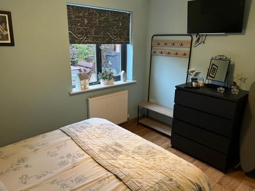 a bedroom with a bed and a dresser and a window at bailiffs cottage annex in Doncaster