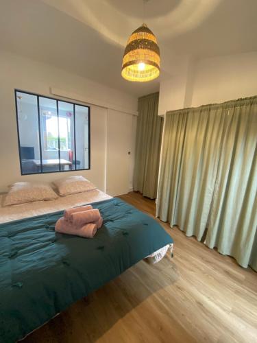 une chambre avec un lit et une grande fenêtre dans l'établissement Petite échoppe Bordeaux, à Bègles