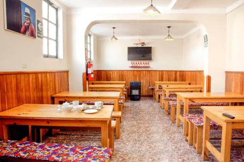 ein Esszimmer mit Holztischen und -stühlen in der Unterkunft Bear Packer Hostel in Cusco