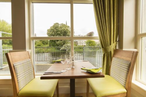 a dining room with a table and chairs and a window at Riverside Hotel in Sligo
