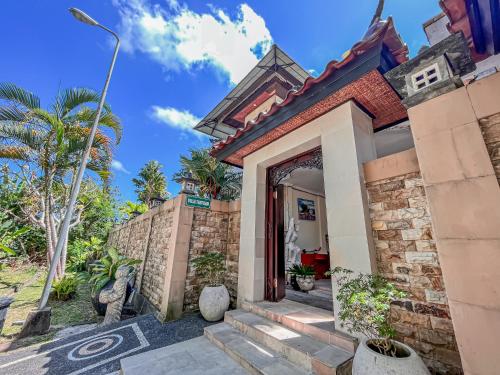 ein Haus mit einem Tor davor in der Unterkunft Villa Tentram Jimbaran by Bali Cabin in Jimbaran