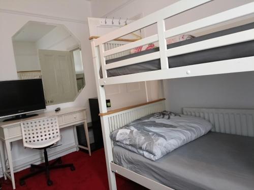 a bedroom with a desk and a bunk bed with a computer at Alys apartment in London