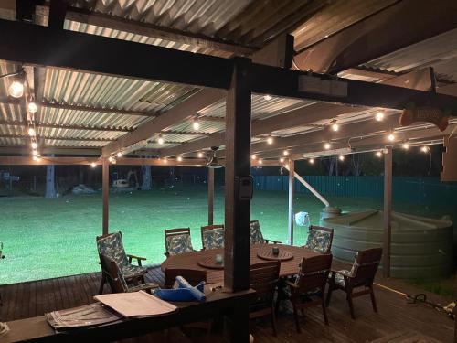 a patio with a table and chairs and lights at The Farm @ Sussex Inlet in Sussex inlet
