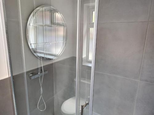 ducha con puerta de cristal y espejo en 5 Fernie ave contractor home in center of Melton Mowbray en Melton Mowbray