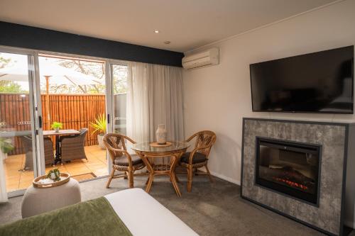 a living room with a fireplace and a table and chairs at Prideau's of Margaret River in Margaret River Town