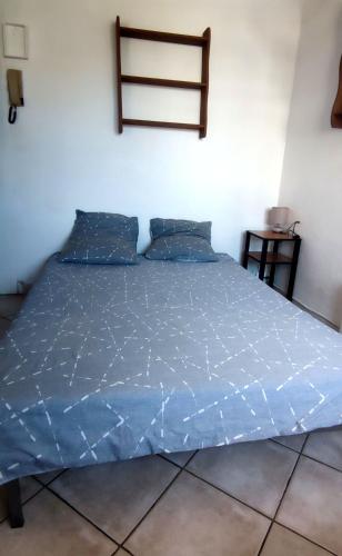 - un lit avec une couette bleue dans l'établissement Petit Studio simple au bord des plages, à La Ciotat