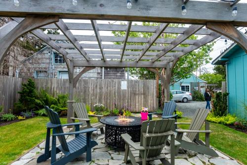 a patio with a table and chairs under a wooden pergola at Inn at Haystack Rock in Cannon Beach