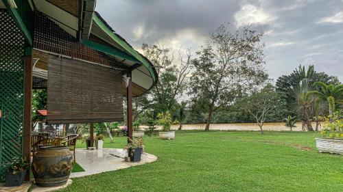 a house with a yard with a grass field at Aaira 8Pari Riverview Lodge in Kota Bharu