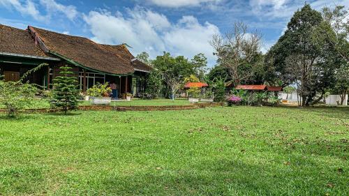 a house with a large yard in front of it at Aaira 8Pari Riverview Lodge in Kota Bharu