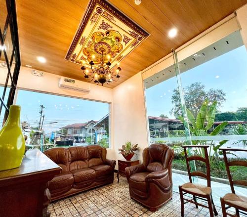 a living room with leather furniture and a large window at E&R Airport Hotel in Dumaguete