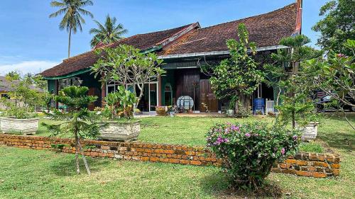 a house with trees and plants in front of it at Aaira 8Pari Riverview Lodge in Kota Bharu