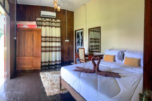 a bedroom with a bed with a towel on it at Aaira 8Pari Riverview Lodge in Kota Bharu