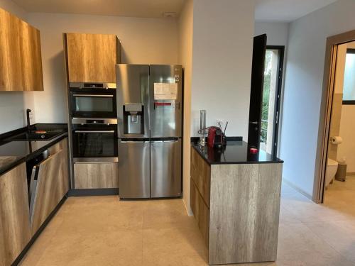 une cuisine avec un réfrigérateur et des armoires en acier inoxydable dans l'établissement Appartement climatisé Pinarello, à Zonza