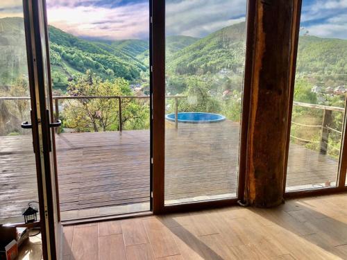 an open door to a balcony with a view of a pool at Cabana Bravak One in Firiza-de-Jos