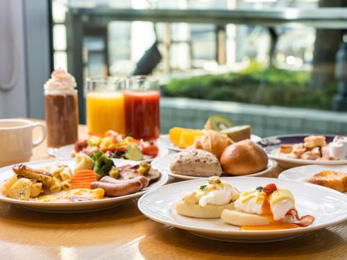 a table with plates of breakfast food on it at Lotte City Hotel Kinshicho in Tokyo