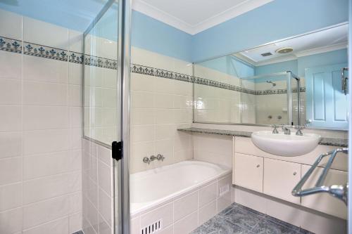 a bathroom with a bath tub and a sink at Aquarius Apartment 7 in Hawks Nest