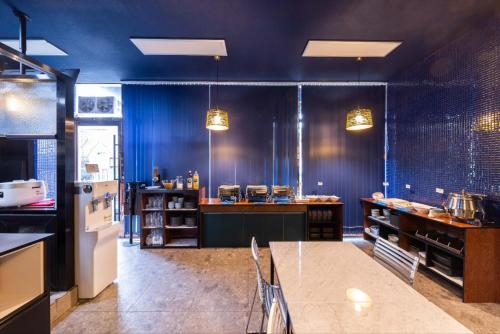 a large kitchen with blue walls and a table in it at Hotel DM in Seoul