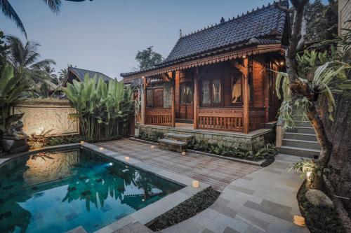 una casa con piscina frente a una casa en Portobello Villa Ubud en Ubud