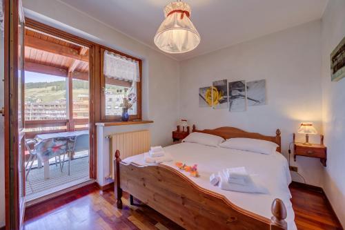 a bedroom with a large bed and a balcony at Sestriere Terrace Apt Few Steps From Ski - Happy Rentals in Sestriere