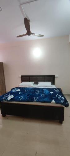 a bed in a bedroom with a ceiling fan at Apna Guest House Dehradun in Dehradun