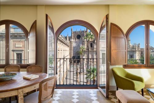 a dining room with a table and a view of a building at Magno Apartments Santo Tomas in Seville