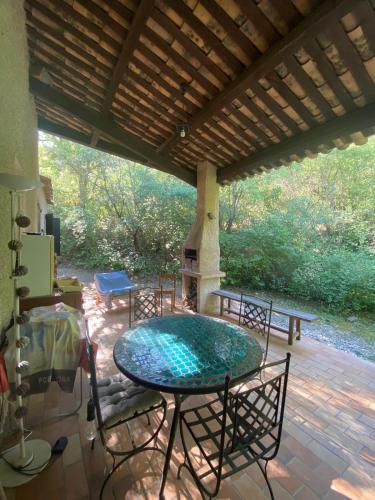 un patio avec une table, des chaises et une cheminée dans l'établissement Belle maison de campagne, à Chaffaut-Lagremuse