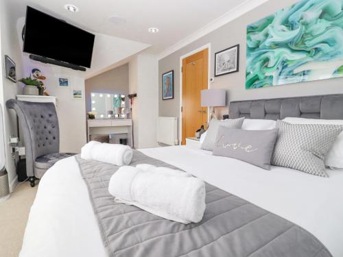 a bedroom with a large bed with white pillows at Ocean Blue in Carbis Bay