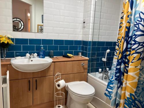 a bathroom with a toilet and a sink and a tub at Dundee City Waterfront, 2 Bedroom 2 Bathroom Apartment - Parking and WIFI, short walk to V and A, Bus & Train Stations in Dundee
