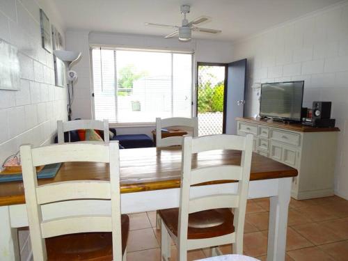 a kitchen and dining room with a table and chairs at Baccarat in Port Vincent