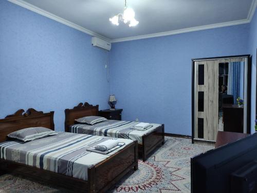 2 Betten in einem Zimmer mit blauen Wänden in der Unterkunft REAL Tashkent in Taschkent